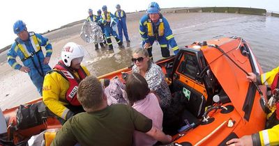 'Terrified' dog walkers cut off by tide are rescued by passerby on jet ski