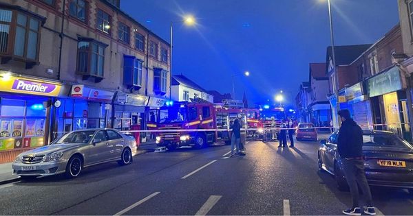 Firefighters search flats after fire ripped through business