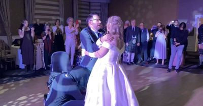 Groom stuns bride as he stands up from wheelchair for first dance at their wedding