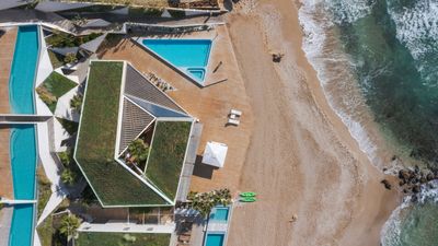 A villa for an art collector blends geometry and rich materials into a spectacular beachside site