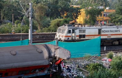 India investigates rail disaster as trains crawl through crash site