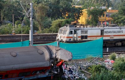 India investigates rail disaster as trains crawl through crash site