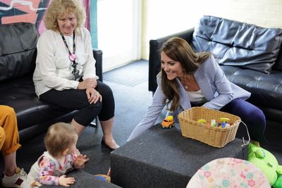 One-year-old baby takes toys from Kate at child support hub