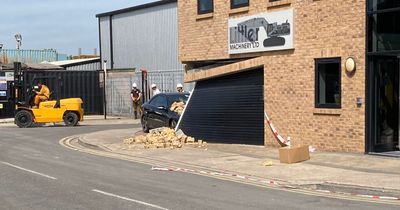 Building evacuated after woman crashes Mercedes through wall