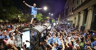 Ecstatic Manchester City fans mount bus stops and smash cars as cops swarm celebrations