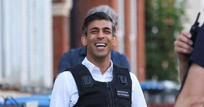 Rishi Sunak laughs with his hands in his pockets as he watches London immigration raid