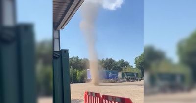 Moment 'mini tornado' dust devil hits yard as workers on break