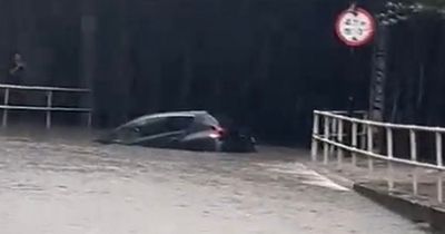 Dramatic moment woman rescued from trapped car as flood warnings issued across UK