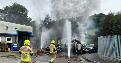 Twisted wreckage and smoking gas canisters after large fire at industrial estate