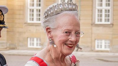 Queen Margrethe of Denmark’s flamingo-pink patterned gown with flattering waist belt proves the royal color of the season isn’t going anywhere