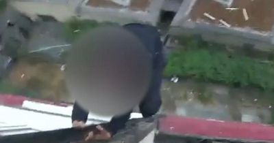 Moment police officer pepper sprays robber dangling from tower block