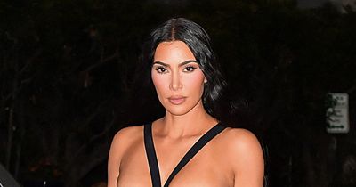 Kim Kardashian flaunts figure in racy black gown as she steals the show at pal's wedding