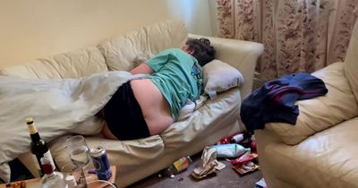 Woman viewing house finds man asleep on sofa surrounded by empty beer bottles