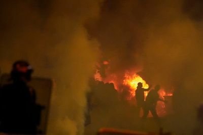 Second night of riots erupt around Paris over police killing of teenager as 150 arrested