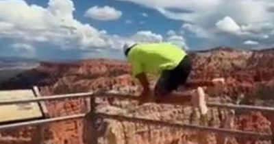 Horrifying moment man jumping canyon barrier loses footing and nearly plunges 800 feet