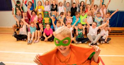 Real life superhero, 8, beats cancer as he 'rings the bell' in front of school