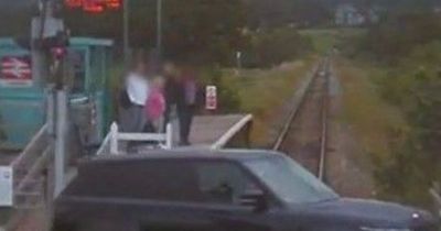 Shocking moment man ignores signs at level crossing and drives into path of moving train