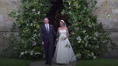 Woman showers newlyweds George Osborne and Thea Rogers in orange confetti
