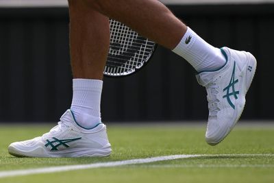 Novak Djokovic plays at Wimbledon with the number '23' printed on his white tennis shoes