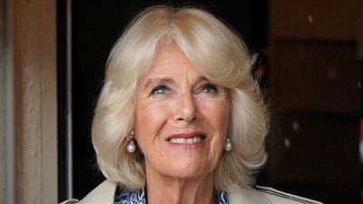 Queen Camilla’s bold blue dress and chic trench coat is the ultimate rainy day combo as she emulates Queen Elizabeth’s wet weather style