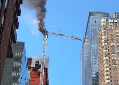 Construction crane catches fire in New York City and hits building as it crashes to street