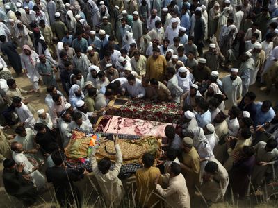 The death toll in the Pakistan suicide bombing rises as families hold funerals