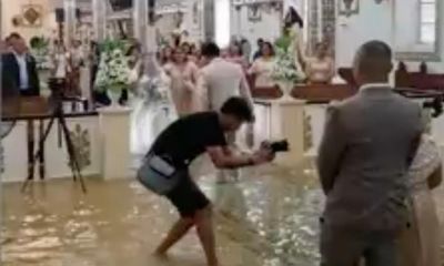 Filipino couple wade through flood waters on wedding day