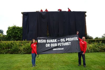 Greenpeace demonstrators drape UK prime minister's house in black to protest oil expansion