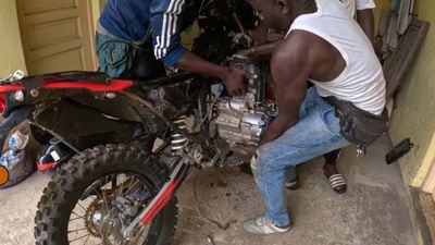 Itchy Boots Repairs Her Bike In The Middle Of West Africa