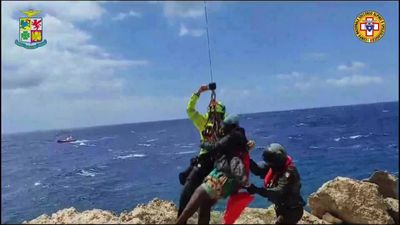 Dozens saved by Italy from migrant shipwrecks; some, clinging to rocks, plucked to safety by copters