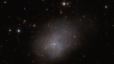 Hubble Space Telescope captures 'ghostly' glow of distant galaxy (photo)