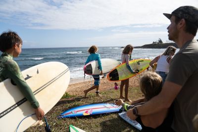 Maui's surf pros paddle out with kids from Lahaina for a healing surf session