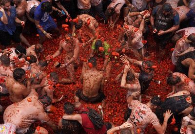 Revelers hurl tomatoes at each other and streets awash in red pulp in Spanish town’s Tomatina party