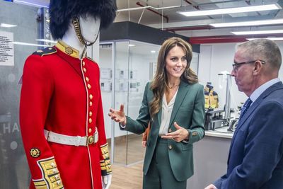 Kate gets the measure of guardsman’s uniform on visit to textile mill