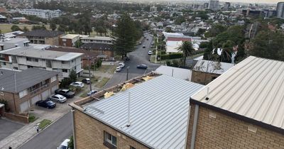 Strong winds tear roof off apartment block at The Hill