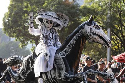 Skeleton marching bands and dancers in butterfly skirts join in Mexico City's Day of the Dead parade