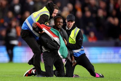 Fan with Palestine flag removed from pitch after Luton score against Liverpool