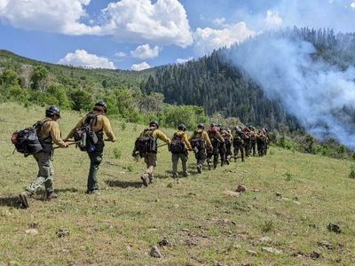 A massive pay cut for federal wildland firefighters may be averted. But not for long