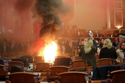 The Albanian opposition disrupts a Parliament vote on the budget with flares and piled-up chairs
