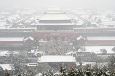 AP PHOTOS: Crowds bundle up to take snowy photos of Beijing's imperial-era architecture