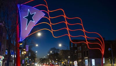 Steel flags on Paseo Boricua shine bright with new lights to illuminate the holiday season