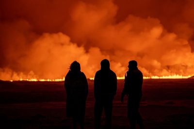 AP PHOTOS: Rivers and fountains of red-gold volcanic lava light up the dark skies in Icelandic town