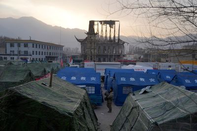 China has started erecting temporary housing units after an earthquake destroyed 14,000 homes