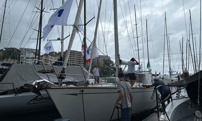 Sydney to Hobart yacht race: fleet sets off under dark skies after heavy storm threatens start