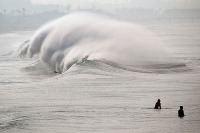 Huge surf pounds beaches on West Coast and in Hawaii with some low-lying coastal areas flooding