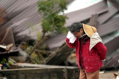 Rescuers race against time in search for survivors in Japan after powerful quakes leave 62 dead