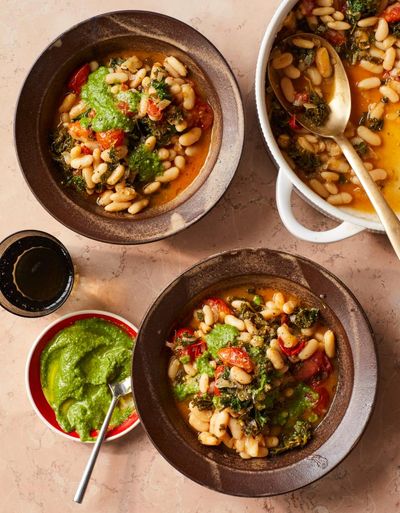 Rukmini Iyer’s quick and easy recipe for pesto-topped white bean, kale and tomato cassoulet