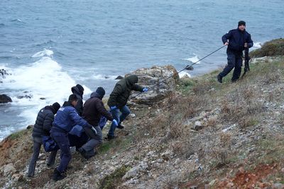 A dinghy carrying migrants hit rocks in Greece, killing 2 people in high winds