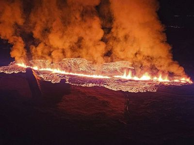 A volcano erupts in Iceland, sending lava flowing toward a nearby town