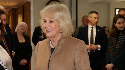 Queen Camilla channels Claudia Winkleman's Traitors style in cosy tartan skirt and statement camel coat